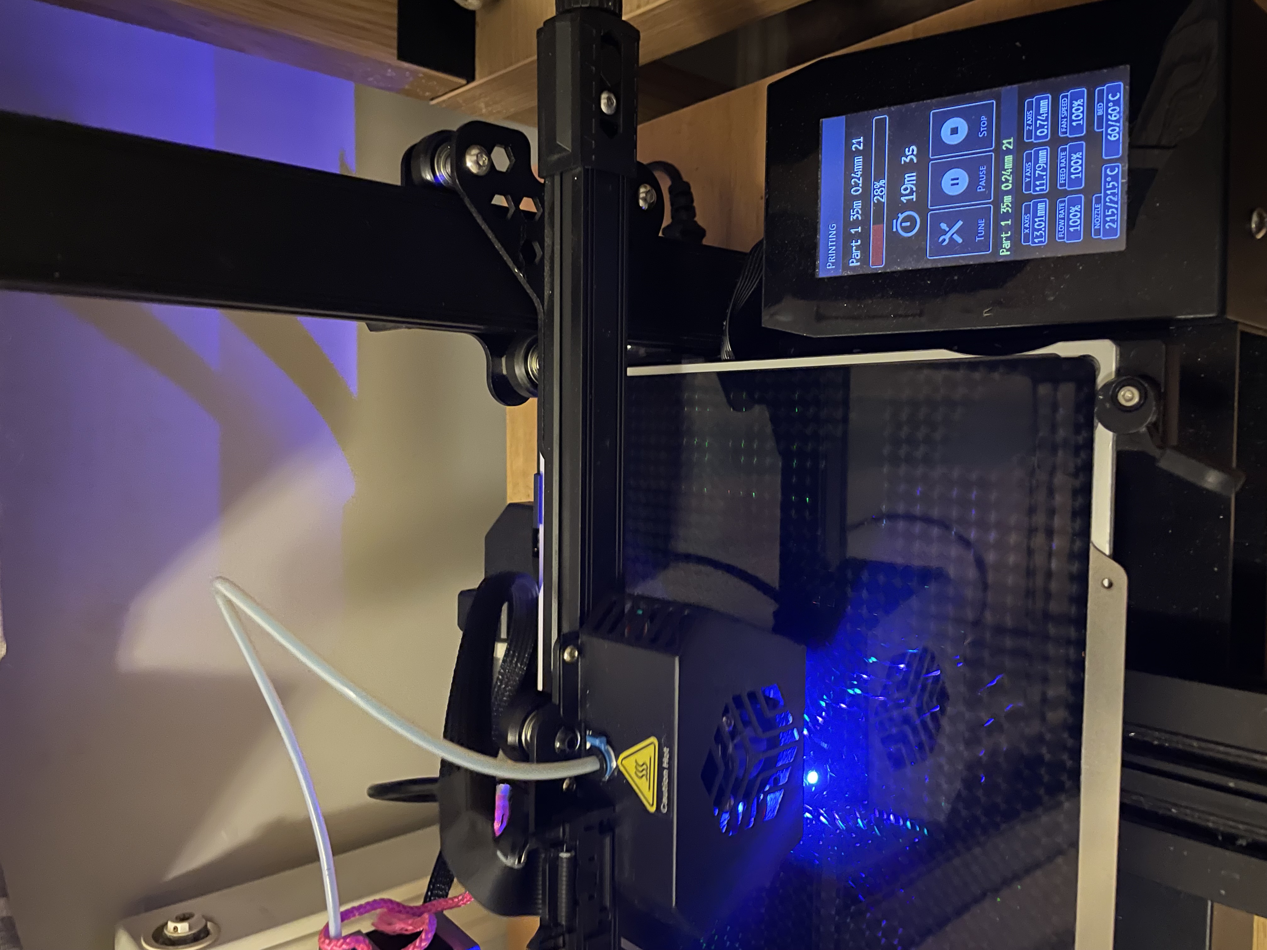 The Creality CR6-SE mid-print, blue LED catching the partially-built token on the build plate